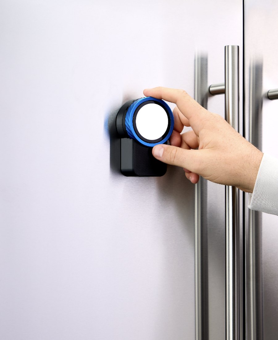 A hand using the Trepo Halo on a fridge door